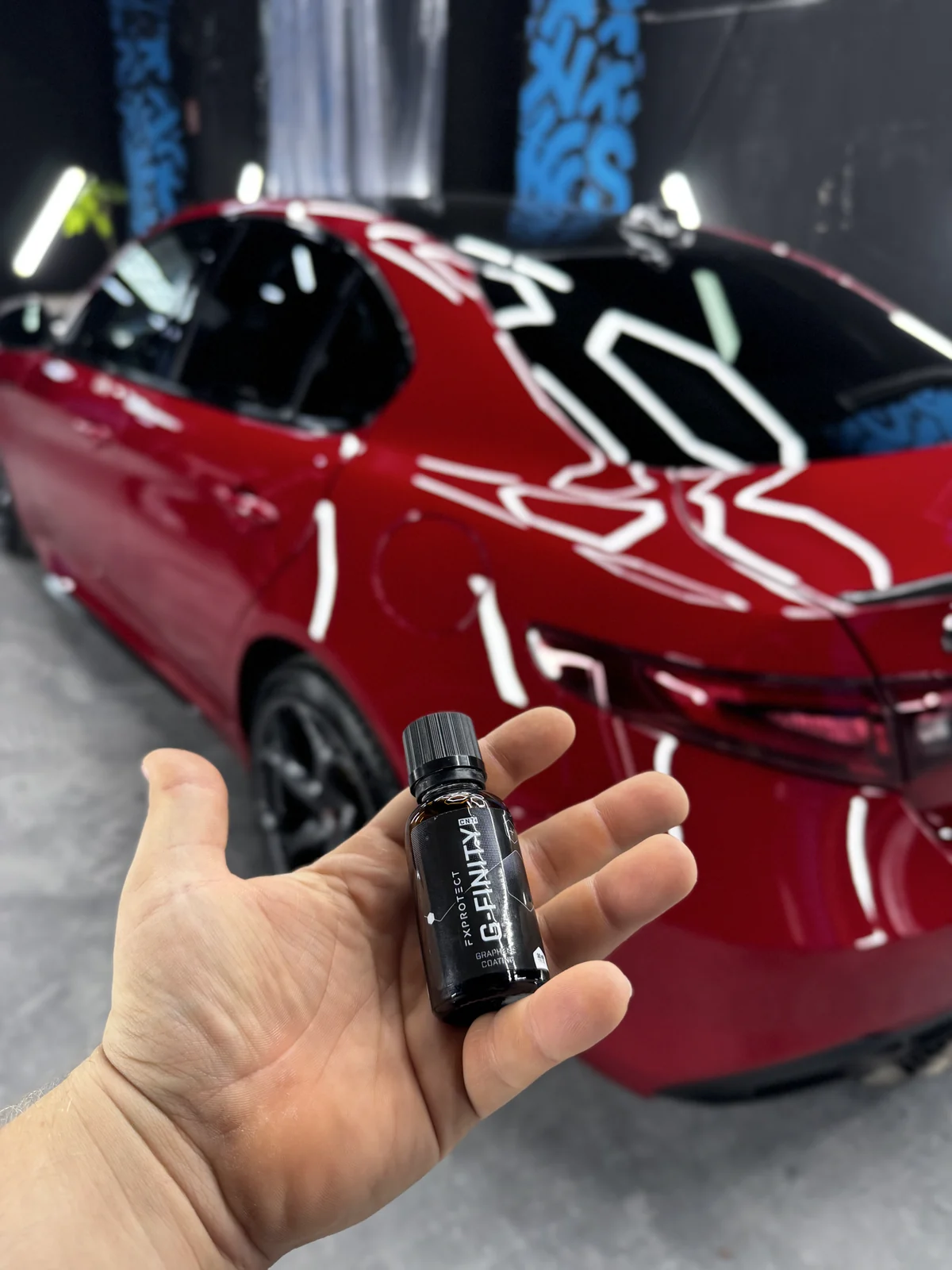Frasco de recubrimiento de grafeno junto a un Alfa Romeo