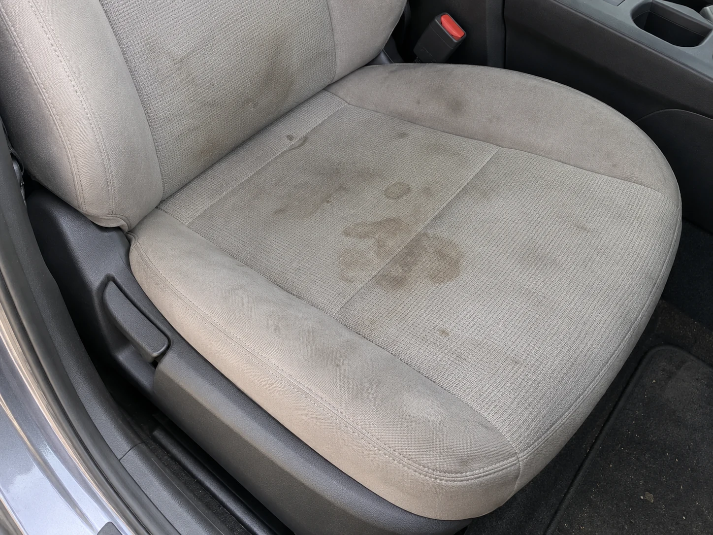 Ejemplo ilustrativo: asiento de tela clara con manchas antes de la limpieza
