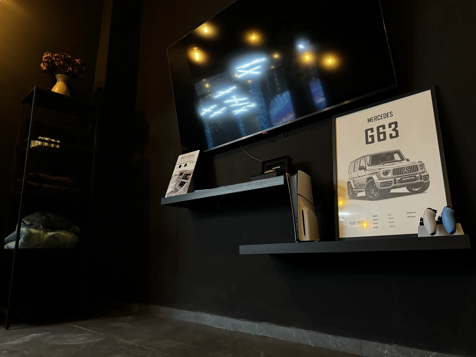 Televisor, consola PlayStation 5 y mandos en el lounge del estudio